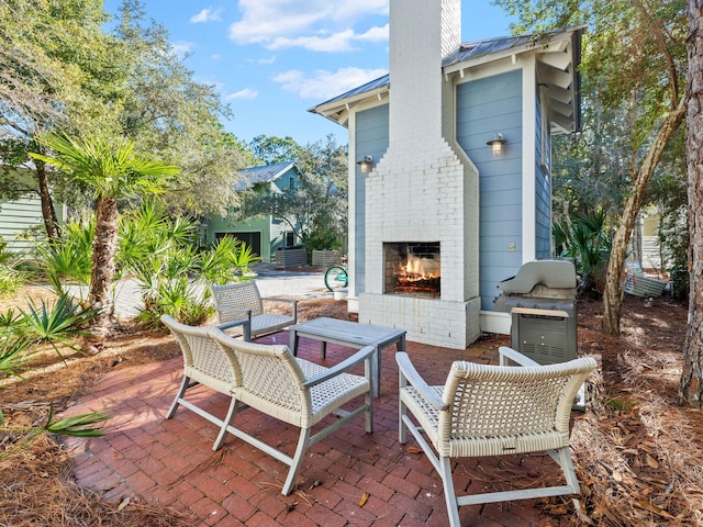 view of patio with an outdoor brick fireplace and area for grilling