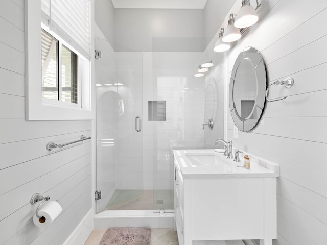 bathroom with wooden walls, vanity, and a shower with shower door