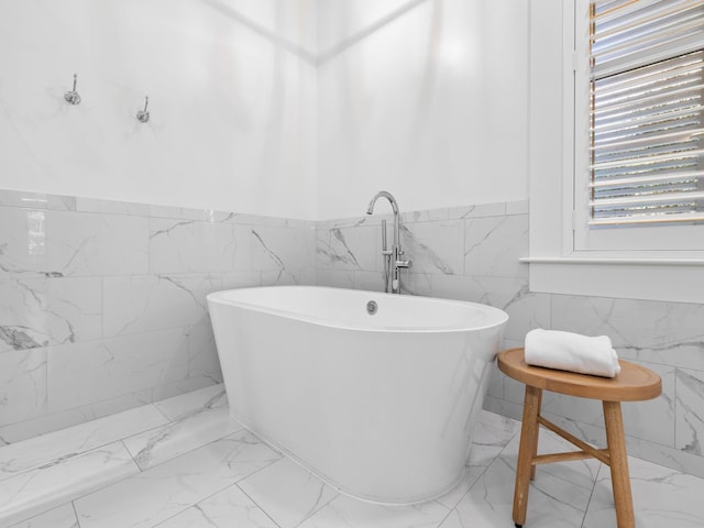 bathroom featuring a bath and tile walls