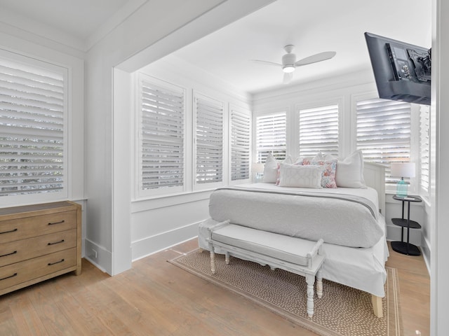 bedroom featuring ceiling fan, light hardwood / wood-style flooring, and ornamental molding