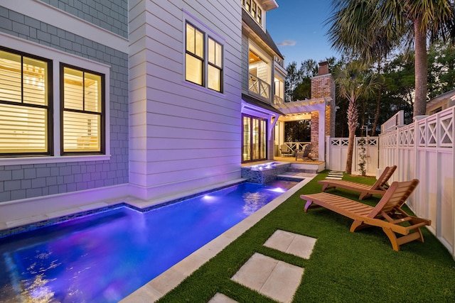 pool at dusk with a pergola and a yard