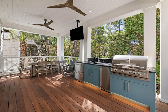 wooden terrace with a grill, ceiling fan, sink, and an outdoor kitchen