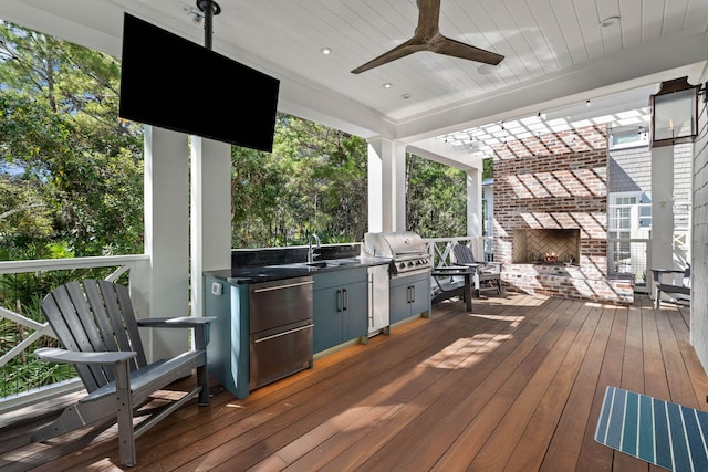 deck with area for grilling, ceiling fan, sink, and an outdoor brick fireplace