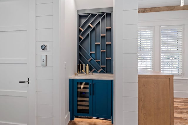 wine area with indoor bar and light wood-type flooring