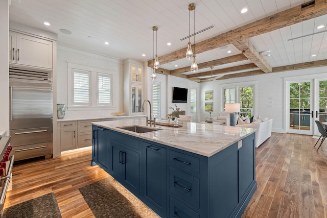 kitchen featuring light hardwood / wood-style floors, white cabinetry, high end fridge, and sink