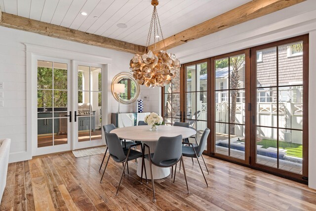 dining space with french doors, light hardwood / wood-style floors, and beam ceiling