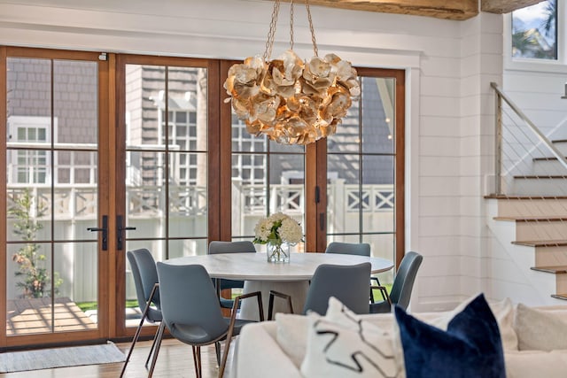 sunroom with a chandelier and french doors