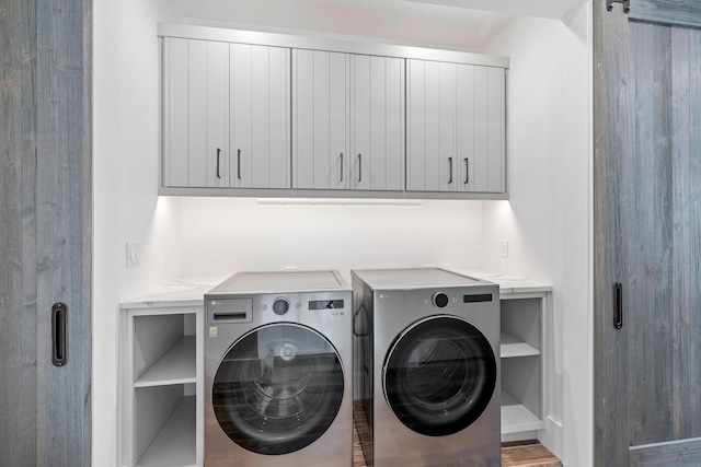 laundry area featuring washer and clothes dryer, cabinets, and hardwood / wood-style floors