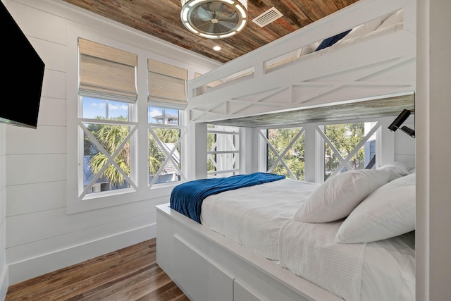 bedroom featuring wood walls, dark wood-type flooring, and wooden ceiling