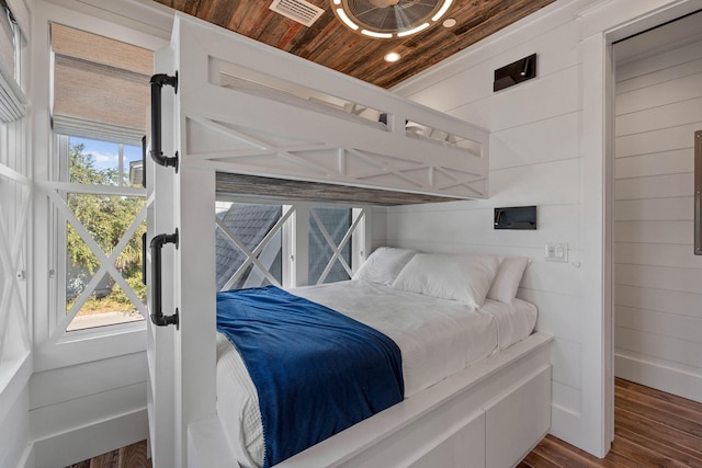 bedroom featuring wood ceiling, dark wood-type flooring, and wooden walls