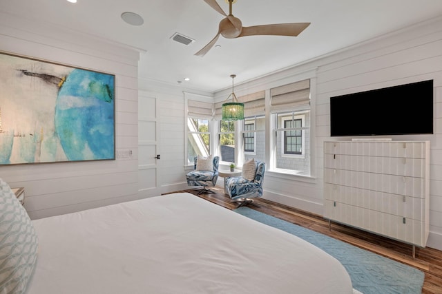 bedroom featuring hardwood / wood-style floors, ceiling fan, and ornamental molding