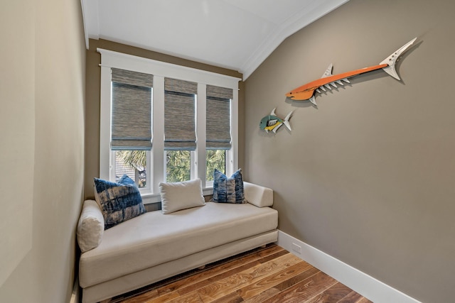 sitting room with wood-type flooring, vaulted ceiling, and crown molding