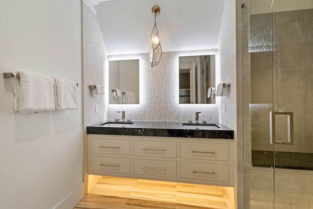 bathroom featuring hardwood / wood-style floors, vanity, and a shower with shower door