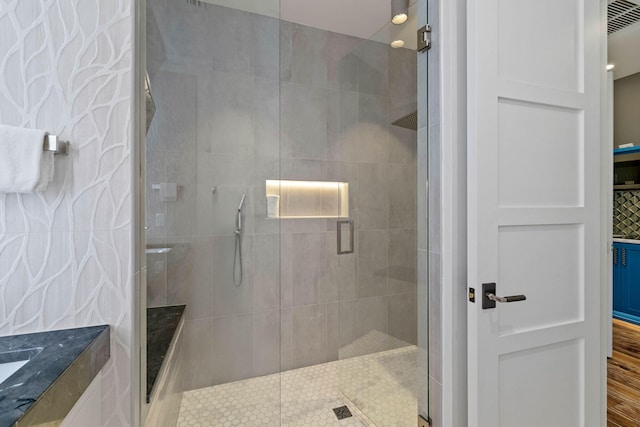 bathroom featuring a shower with shower door and hardwood / wood-style flooring