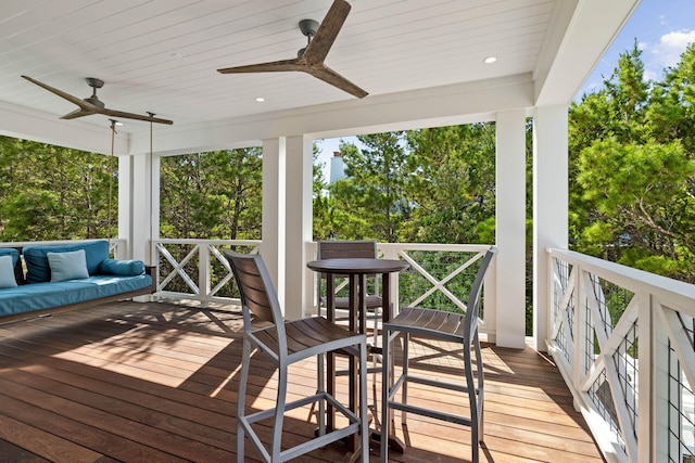 wooden terrace with an outdoor hangout area and ceiling fan