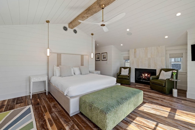 bedroom featuring vaulted ceiling with beams, dark wood-type flooring, and a tiled fireplace