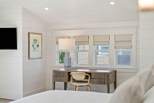 bedroom with wooden walls and lofted ceiling