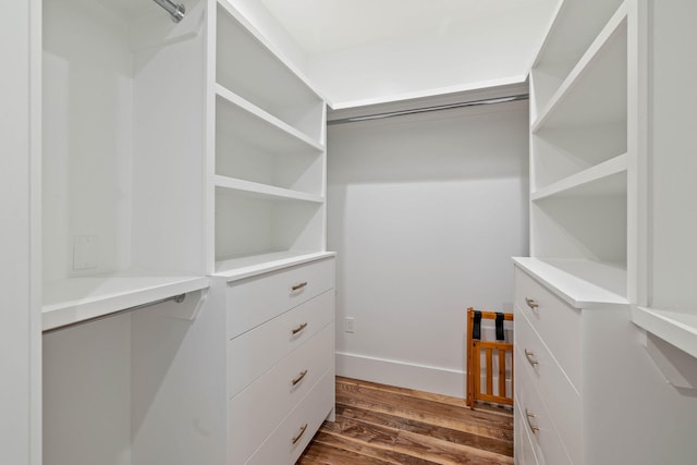 spacious closet with dark hardwood / wood-style flooring