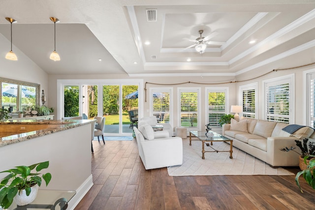 living room with hardwood / wood-style flooring, a raised ceiling, plenty of natural light, and ceiling fan