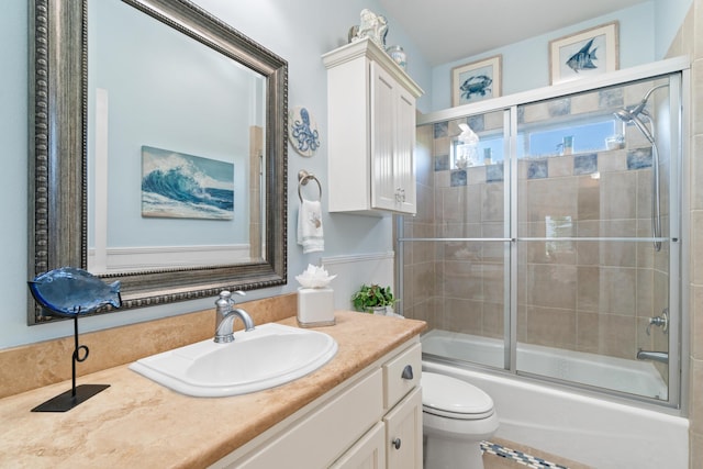 full bathroom with vanity, toilet, and bath / shower combo with glass door