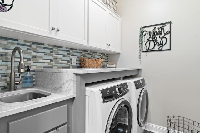 washroom featuring cabinets, sink, and washing machine and clothes dryer