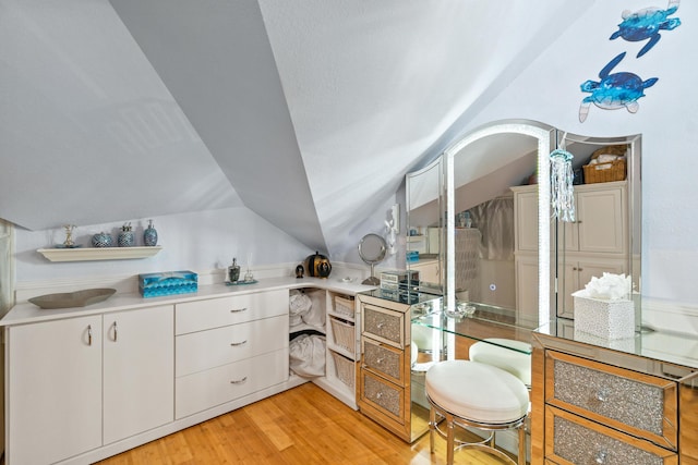 bathroom with wood-type flooring and lofted ceiling