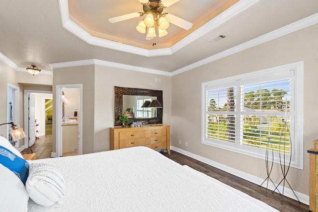 bedroom with a tray ceiling, crown molding, ceiling fan, and dark wood-type flooring