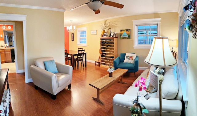 living room with hardwood / wood-style floors, ceiling fan with notable chandelier, and ornamental molding