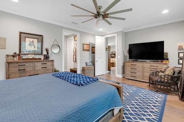 bedroom featuring ceiling fan, crown molding, and light hardwood / wood-style floors