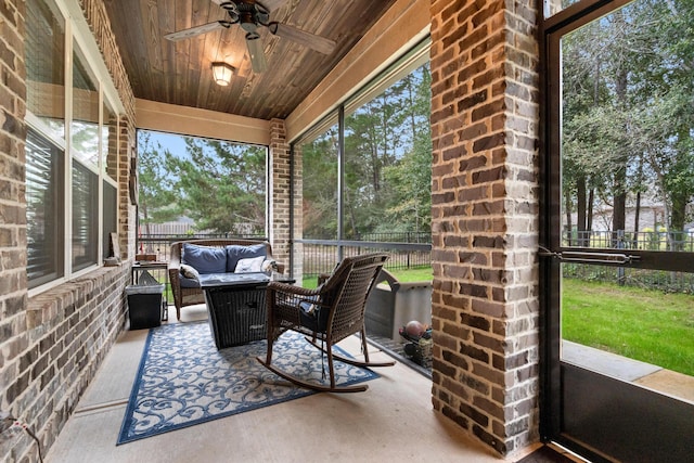 sunroom featuring ceiling fan and wooden ceiling