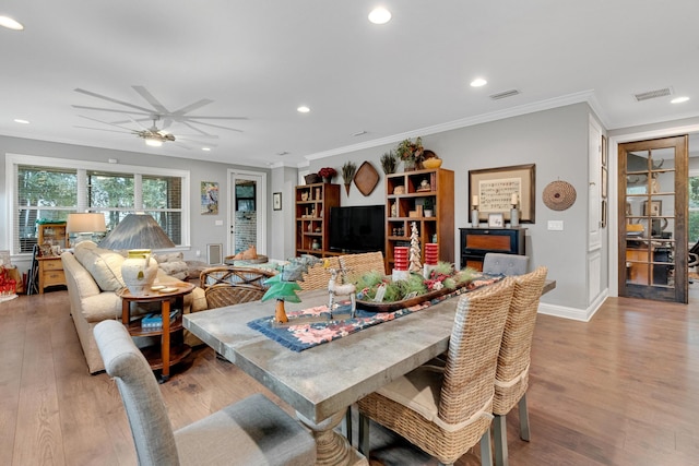 dining area with crown molding, light hardwood / wood-style flooring, and ceiling fan