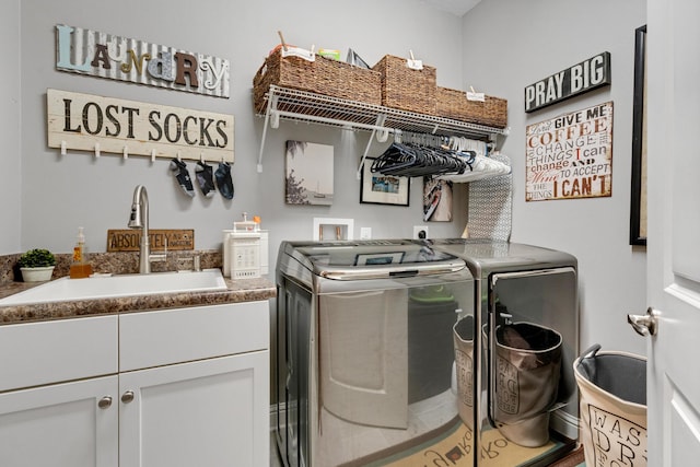 clothes washing area with cabinets, independent washer and dryer, and sink