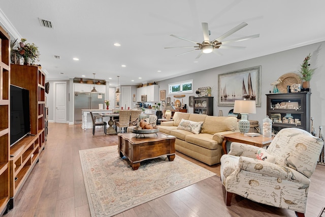 living room with ceiling fan and light hardwood / wood-style flooring