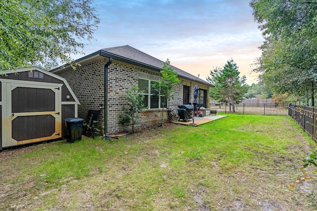 exterior space with a patio, a storage unit, and a lawn