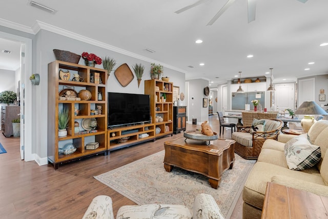 living room with hardwood / wood-style floors, ceiling fan, and ornamental molding