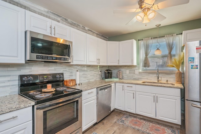 kitchen featuring white cabinetry, sink, light hardwood / wood-style floors, and appliances with stainless steel finishes