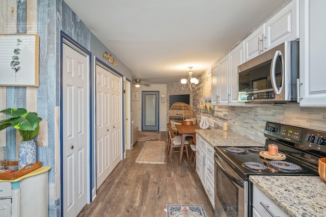 kitchen with white cabinetry, light stone countertops, tasteful backsplash, light hardwood / wood-style flooring, and appliances with stainless steel finishes