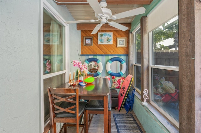 sunroom featuring ceiling fan and beam ceiling