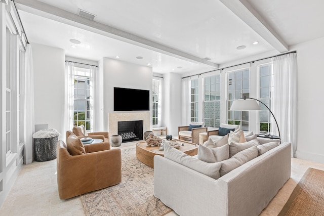 living room featuring beamed ceiling and a wealth of natural light