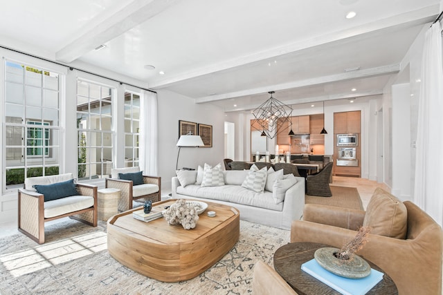 living room featuring beam ceiling and an inviting chandelier