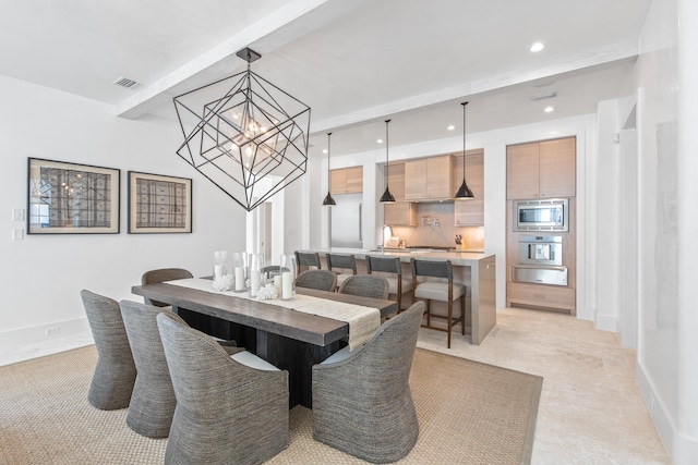 dining space with sink and a notable chandelier