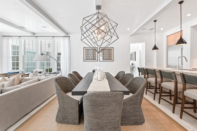 dining area featuring sink, light colored carpet, and an inviting chandelier