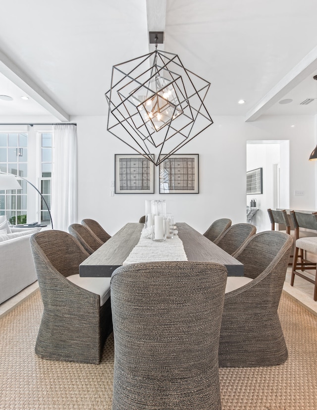 dining area with a chandelier, carpet floors, and beamed ceiling