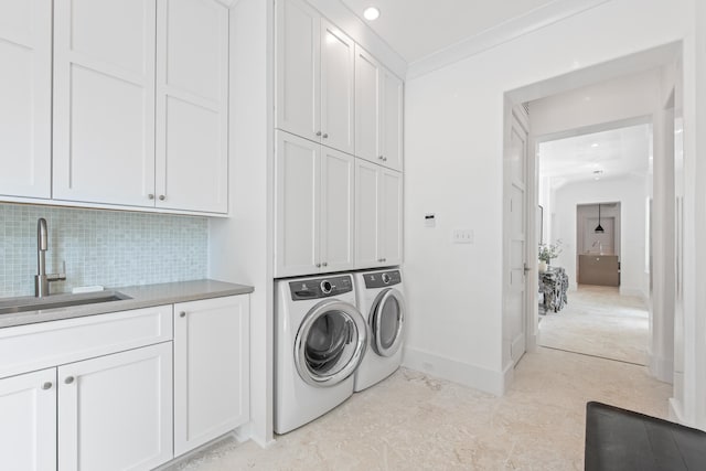 laundry area featuring cabinets, separate washer and dryer, and sink