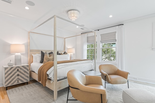 bedroom featuring light hardwood / wood-style floors and an inviting chandelier