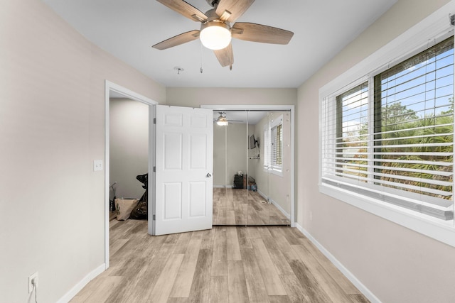 unfurnished bedroom featuring ceiling fan, light wood-type flooring, and a closet