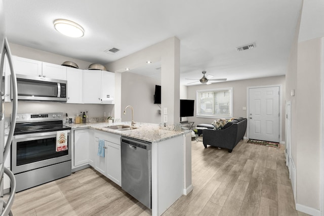 kitchen featuring kitchen peninsula, sink, white cabinets, and stainless steel appliances