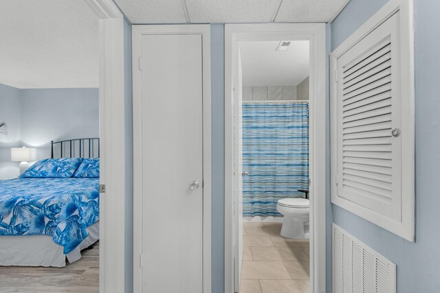 tiled bedroom featuring connected bathroom