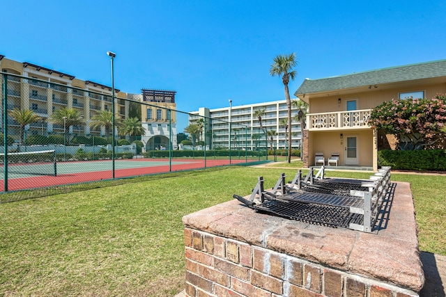 view of community featuring a yard and tennis court