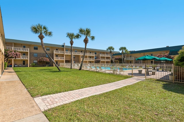 surrounding community with a pool and a yard
